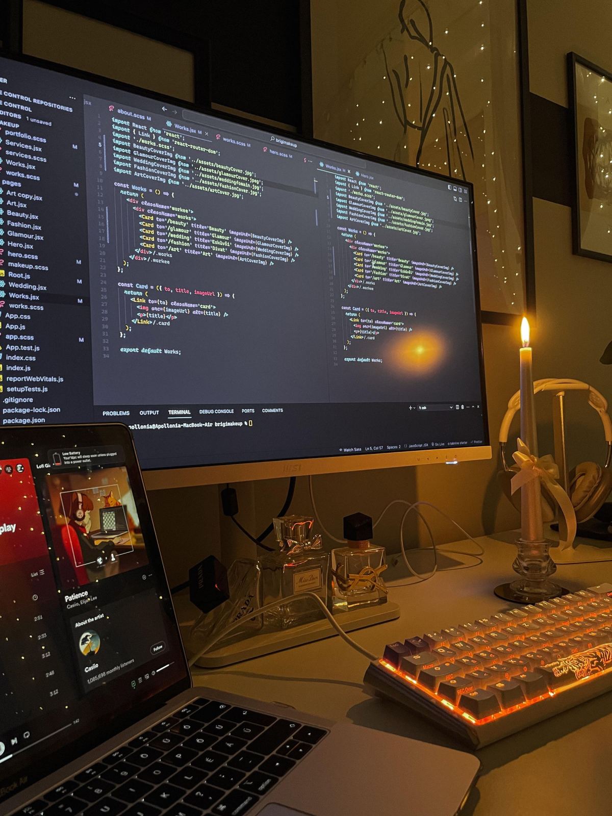 A quiet, warmly lit coding workspace with a screen of code and a lit candle